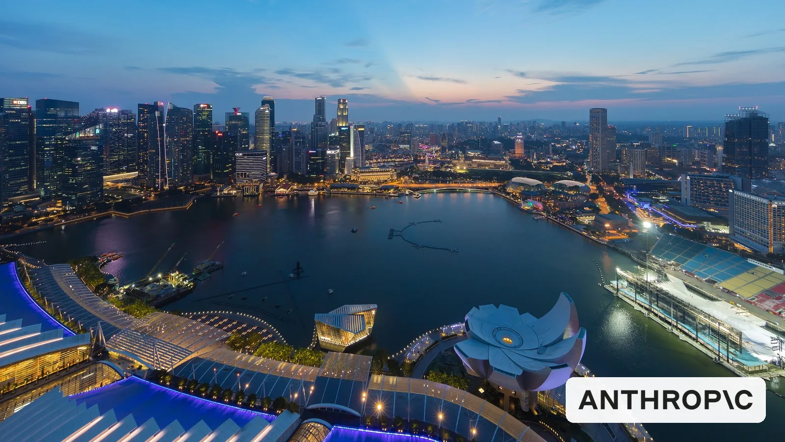 Singapore's Central Business District skyline at dusk, with the Anthropic logo