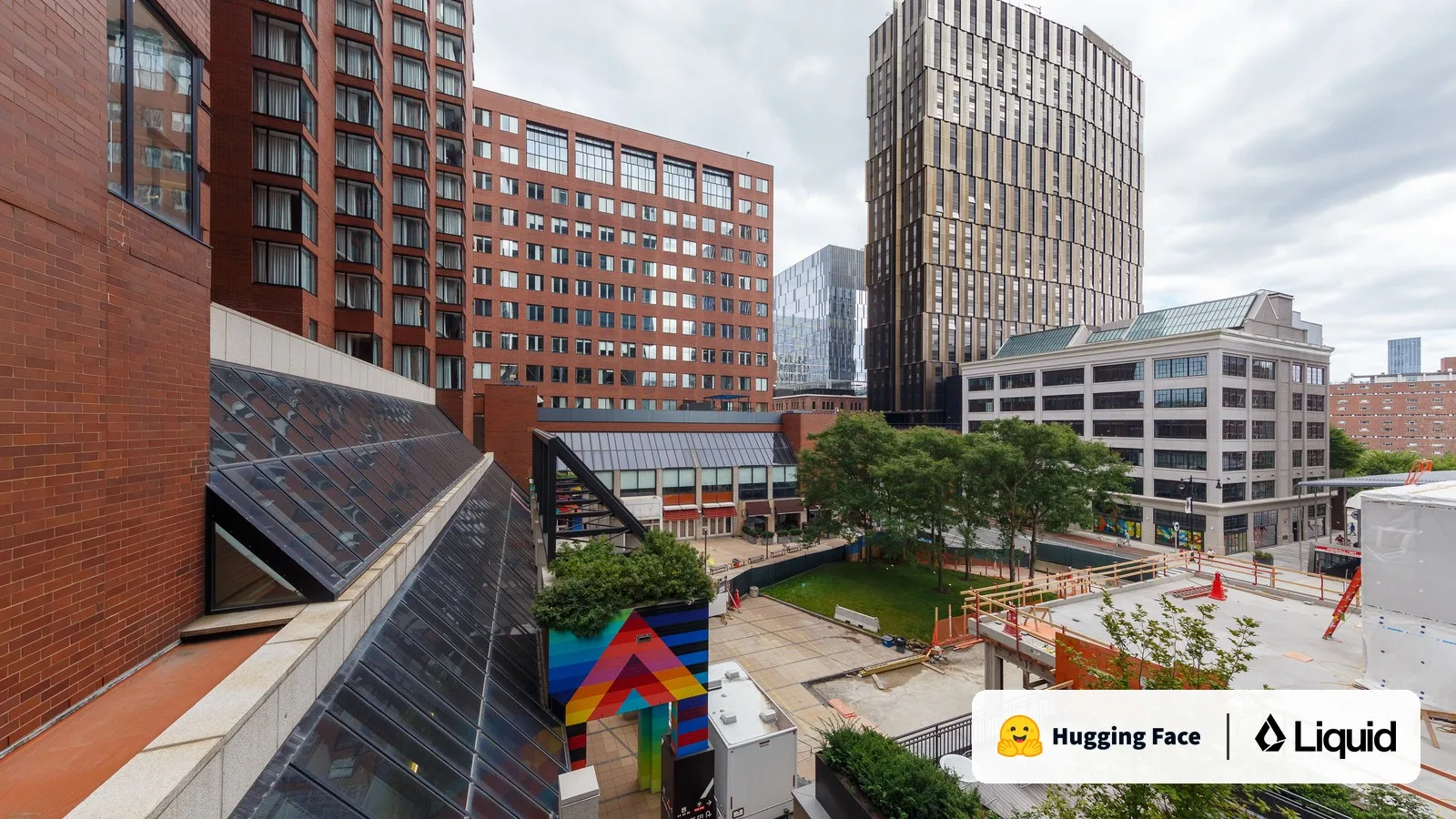 The Kendall Square neighborhood of Cambridge, Massachusetts, with the Hugging Face and Liquid AI logos