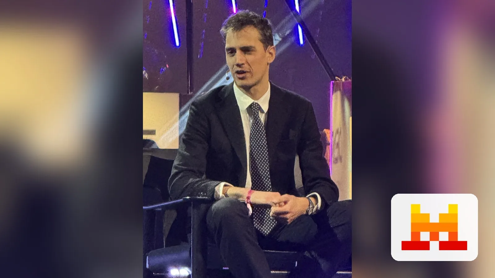 Mistral AI CEO Arthur Mensch, with the Mistral AI logo
