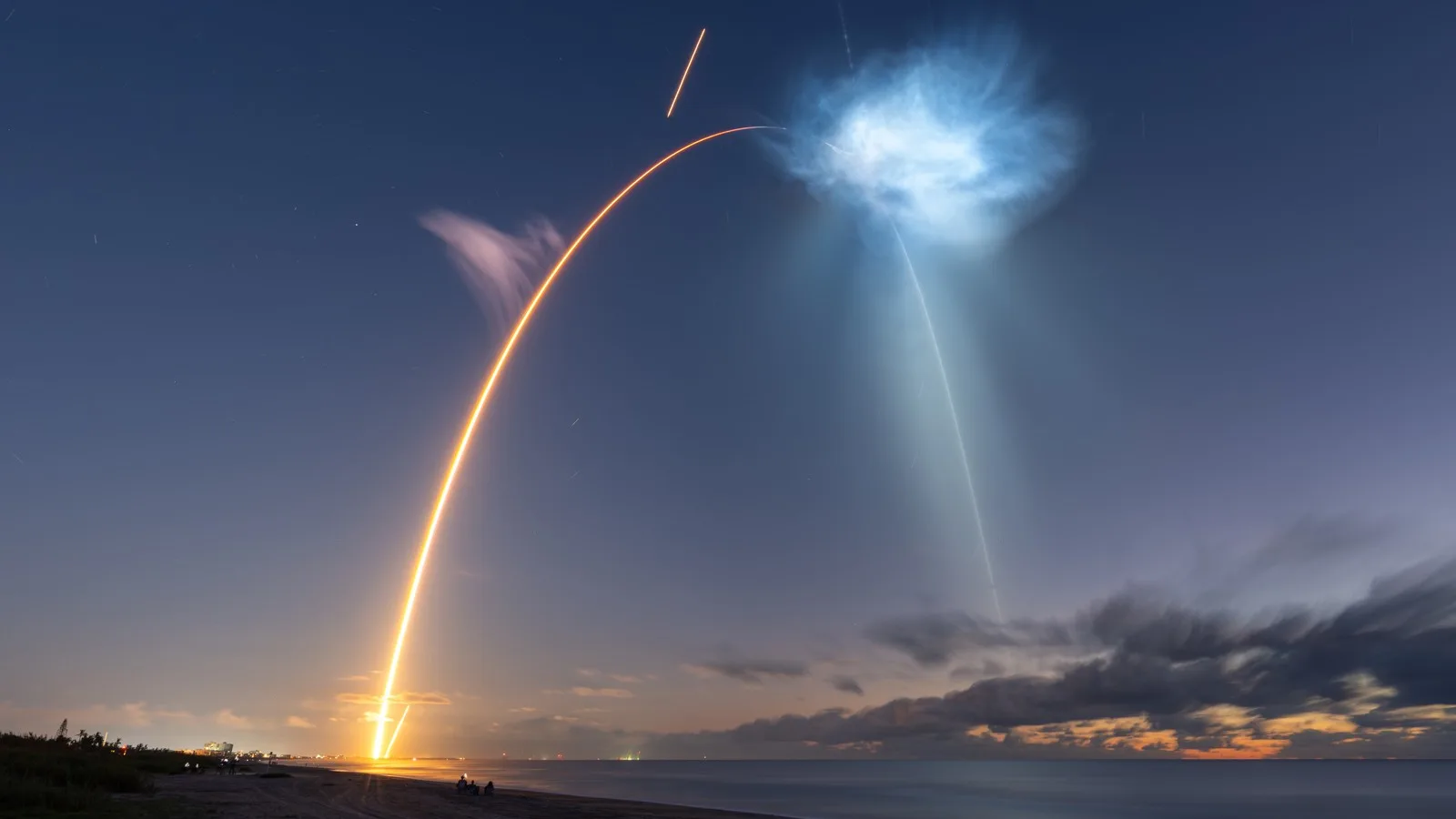 Long-exposure photo of the Falcon 9 launch of CRS-35 and its first stage returning to land, seen from Cocoa Beach, Florida